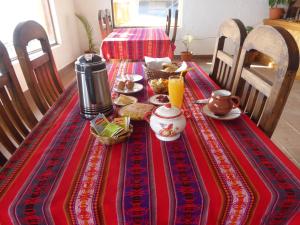 a table with a red table cloth with food on it at CAMPO SANTO in Comunidad Yumani