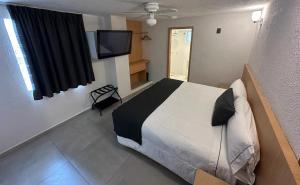 Schlafzimmer mit einem Bett und einem Flachbild-TV in der Unterkunft Hotel Emperador centro Guadalajara y Remodelado in Guadalajara