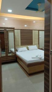 1 dormitorio con 1 cama grande y espejo en Parth Hotel, en Navi Mumbai