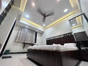 1 dormitorio con 1 cama y ventilador de techo en Parth Hotel, en Navi Mumbai
