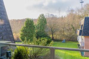 a balcony with a view of a yard with trees at Koje Seaside in Harrislee