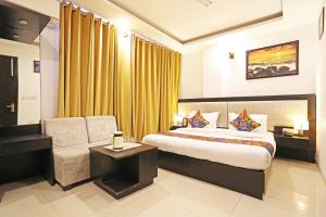 Habitación de hotel con cama y silla en Airport Hotel Swan Near Delhi Airport en Nueva Delhi