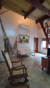 a living room with a hammock and a couch at Pousada Vale da Neblina in Ubajara