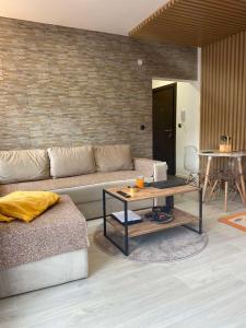 uma sala de estar com um sofá e uma mesa em Apartman Breza - Vila Umine Vode em Zlatibor