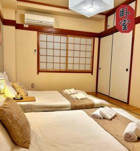 dwa łóżka w pokoju w obiekcie 悦然民宿 w Osace