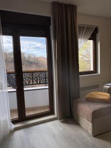 um quarto com uma janela com vista para uma varanda em Apartman Breza - Vila Umine Vode em Zlatibor