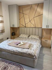 um quarto com uma cama grande e uma cabeceira em madeira em Apartman Breza - Vila Umine Vode em Zlatibor