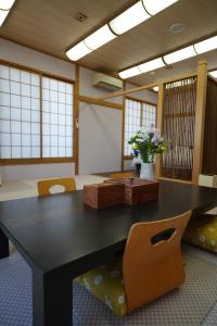 白浜・温泉リゾート海岳 في شيراهاما: غرفة طعام مع طاولة سوداء كبيرة وكراسي