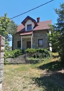 una casa de piedra con techo rojo en Pelister Riverside Villa, en Bitola