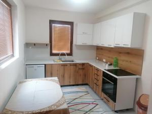 una cocina con armarios blancos y fregadero en Pelister Riverside Villa, en Bitola