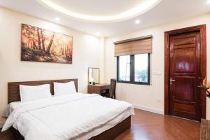 een slaapkamer met een groot wit bed en een raam bij H2B WESTLAKE in Hanoi