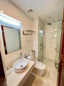 een badkamer met een wastafel, een toilet en een douche bij H2B WESTLAKE in Hanoi