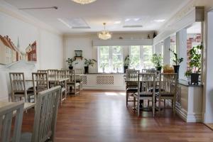 uma sala de jantar com mesas e cadeiras num quarto em Park Hotel Linköping Fawlty Towers em Linköping