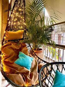 アテネにある100 m2 Apartment in the center of Athensの植物のある部屋の枕付きの椅子