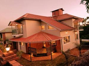 a house with a gazebo in front of it at Forest Nature Villa in Mahabaleshwar