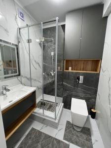 a bathroom with a shower and a toilet and a sink at Сдается новая квартира in Karakol