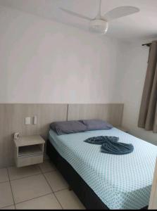 a bedroom with a bed with a blue comforter at Apartamento 3 Quartos - 807D in Contagem