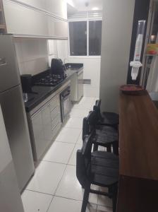 a kitchen with a counter and some chairs in it at Apartamento 3 Quartos - 807D in Contagem