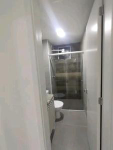 a small bathroom with a toilet and a shower at Apartamento 3 Quartos - 807D in Contagem