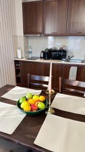 a bowl of fruit on a table in a kitchen at ELEA Apartment Mountain Lodge Pamporovo in Pamporovo