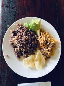 einen Teller mit Reis und Salat auf dem Tisch in der Unterkunft CARIBbEAN Paradise Hotel in Lanquín