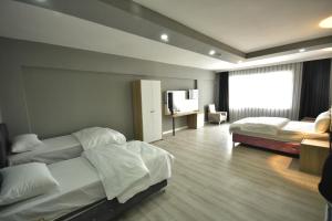 a hotel room with two beds and a television at Rio's Hotel AİRPORT in Istanbul