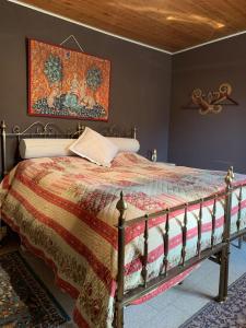 1 dormitorio con 1 cama con un edredón colorido en La baia dei lupi, en Rezzano