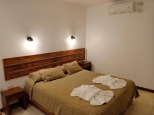 a bedroom with a bed with two towels on it at Urban Hotel in Federación