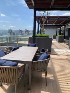 een houten tafel en stoelen op een dak bij Neu Suites Ampang in Kuala Lumpur