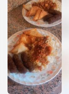 Shipa's nubian house في أسوان: طبقين من الطعام على طاولة مع طعام