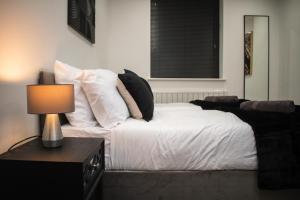 - une chambre avec un lit doté de draps et d'oreillers blancs dans l'établissement Exquisite 2-Bedroom City Centre Haven - Leicester's Premier Urban Retreat, à Leicester