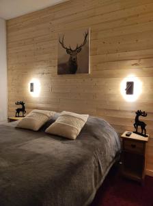 1 dormitorio con 1 cama con una foto de ciervo en la pared en Hotel Plein Soleil en Allos