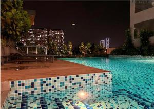 een zwembad 's nachts met een gebouw bij Neu Suites Ampang in Kuala Lumpur