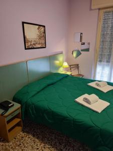 una camera da letto con un piumone verde su un letto di Hotel Etrusco a Sesto Fiorentino
