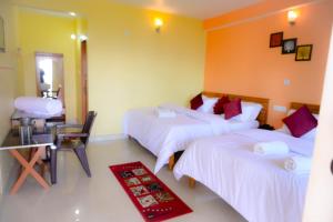 um quarto de hotel com duas camas e uma casa de banho em JMT Eco-Binsar by StayApart em Panuānaula