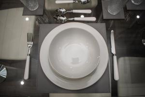 a table with a plate and utensils on a table at Exquisite 2-Bedroom City Centre Haven - Leicester's Premier Urban Retreat in Leicester