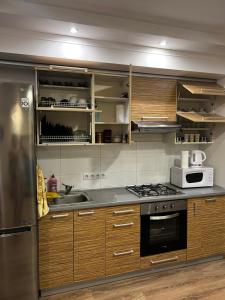 a kitchen with wooden cabinets and a stove top oven at VIP апартаменти ЦЕНТР in Rivne