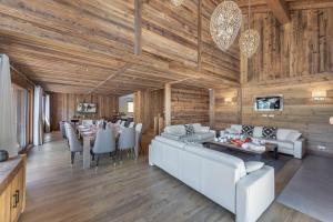 un soggiorno con mobili bianchi e pareti in legno di Chalet Kashmir 5MIN des pistes en voiture parking privé, spa, sauna a Les Allues