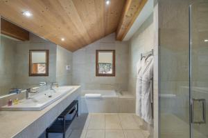un bagno con vasca, lavandino e doccia di Chalet Kashmir 5MIN des pistes en voiture parking privé, spa, sauna a Les Allues Altre 24 foto