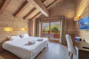 a bedroom with a bed and a desk and a window at Chalet Kashmir 5MIN des pistes en voiture parking privé, spa, sauna in Les Allues