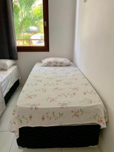 a twin bed in a room with a window at Flat Barra do Cunhaú in Canguaretama