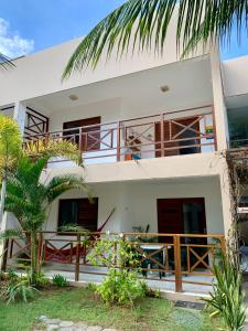 Canguaretama的住宿－Flat Barra do Cunhaú，带阳台的白色房屋和棕榈树