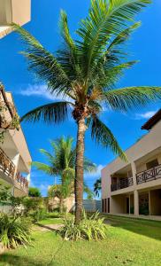 a palm tree in front of a building at Flat Barra do Cunhaú in Canguaretama