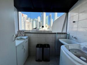 baño con vistas a la ciudad desde una ventana en Cobertura Baixa Coral Gables, en Balneário Camboriú