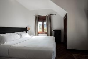 a bedroom with a large white bed and a window at Angelats Hotel in Ribes de Freser