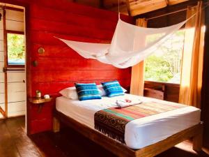 Un dormitorio con una cama con una red encima. en Hostal Doble Vista en Capurganá