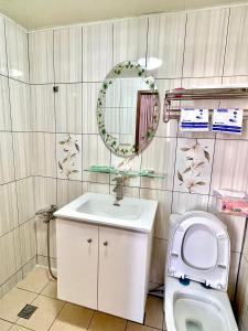 a bathroom with a sink and a toilet and a mirror at Wayu House in Shang-wu