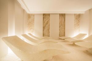 a room with white chairs and a table at Hotel Regina Elena 57 & Oro Bianco SPA in Rimini