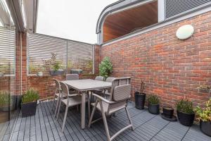 倫敦的住宿－Stylish house with superb space，一个带桌椅和砖墙的庭院