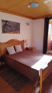 ein Schlafzimmer mit einem großen Bett in einem Zimmer in der Unterkunft Casa do Galvão -Turismo Rural - Serra da Estrela in Aguincho + 12 Fotos